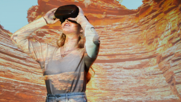 woman using virtual reality headset with desert landscape in background