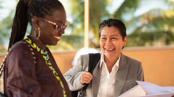 Two women smiling and conversing at the Mastercard Foundation Scholars Program e-Learning Initiative Summit