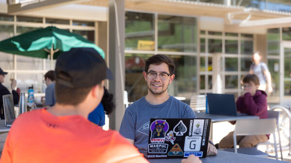 Students sitting at a table, engaging in discussion.